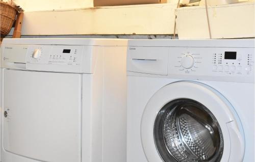 a white washer and dryer in a room with boxes at Gorgeous Home In Skivarp With Sauna in Skivarp