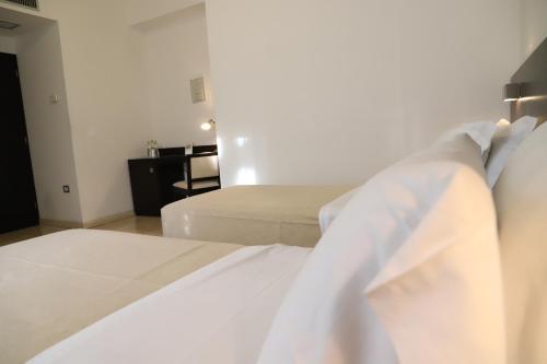 a bedroom with two beds with white sheets at Albergo Cantiani in Ancona
