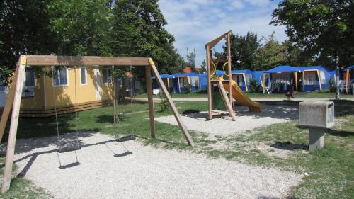 une aire de jeux avec balançoire et certaines tentes dans l'établissement Happy Camp Mobile Homes in Camping Terme Čatež, à Čatež ob Savi