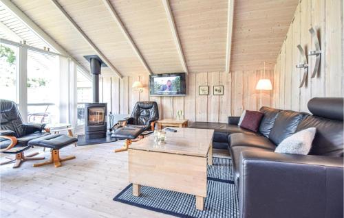 a living room with a couch and a fireplace at Awesome Home In Blåvand With Wifi in Blåvand