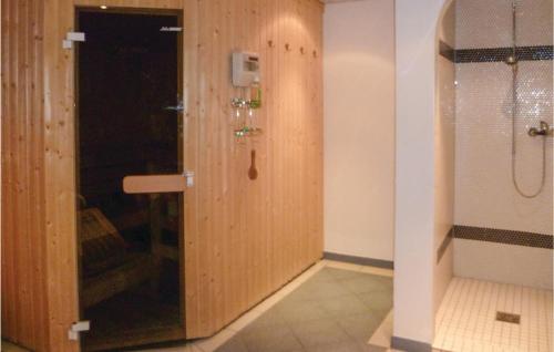 イシュグルにあるStunning Apartment In Ischgl With 2 Bedrooms, Sauna And Wifiのバスルーム(シャワー付)、木製のドアが備わります。