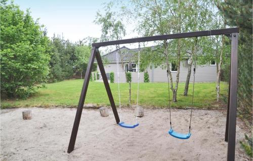 a swing set in a yard with a house at Pet Friendly Home In Ansager With Sauna in Ansager