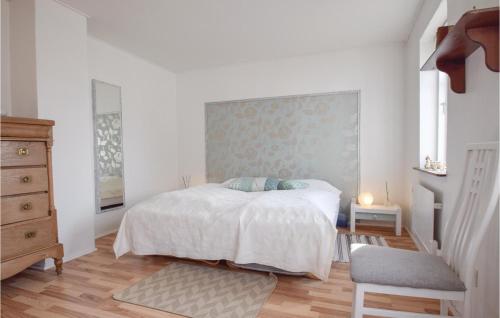 a white bedroom with a bed and a chair at 3 Bedroom Stunning Home In Tranekær in Tranekær