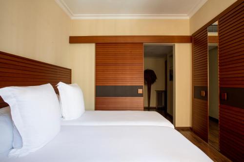 a bedroom with a large bed with white pillows at Hotel Astoria in Barcelona