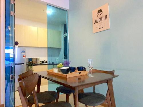 a kitchen with a wooden table and chairs in a room at The Wave Suites Melaka in Melaka