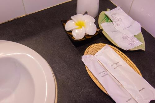 uma mesa com um prato e uma tigela de flores em Gusto Pratunam Hotel em Bangkok