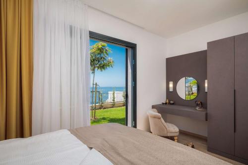 a bedroom with a bed and a view of the ocean at Villa Four Brothers - Exclusive Apartment in Podstrana
