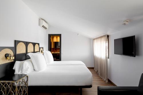 a hotel room with two beds and a television at Hotel Astoria in Barcelona