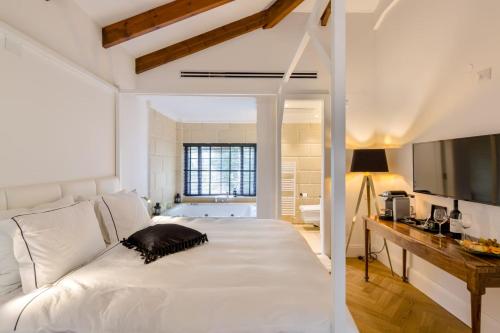 a bedroom with a white bed and a bathroom at Villa Galilee Boutique Hotel and Spa in Safed