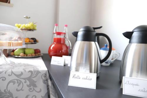 two silver and black kettles sitting on a counter at Albergo Cantiani in Ancona