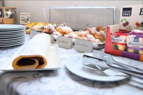 a table with a plate of food and pastries on it at Albergo Cantiani in Ancona