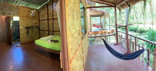 a room with a hammock in a house at Easylife Bungalow in Ko Lanta