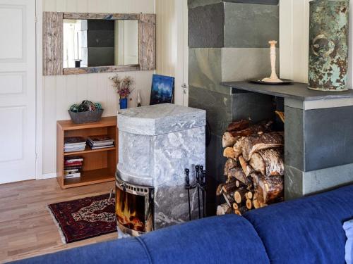 a living room with a fireplace and a blue couch at 4 star holiday home in Hennes in Hennes