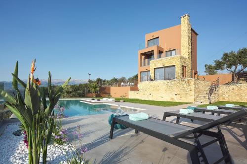 a villa with a swimming pool and a house at Villa Niolos II in Stérnai