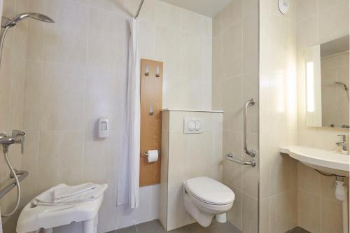 uma casa de banho branca com um WC e um lavatório em B&B HOTEL Lens Musée Du Louvre em Lens