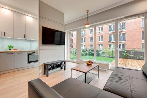 a living room with a couch and a table at Central Apartment - free private parking in Gdańsk
