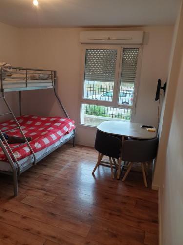Cette chambre comprend des lits superposés, une table et des chaises. dans l'établissement Studio à 1 kilomètre de Disneyland Paris, à Montévrain