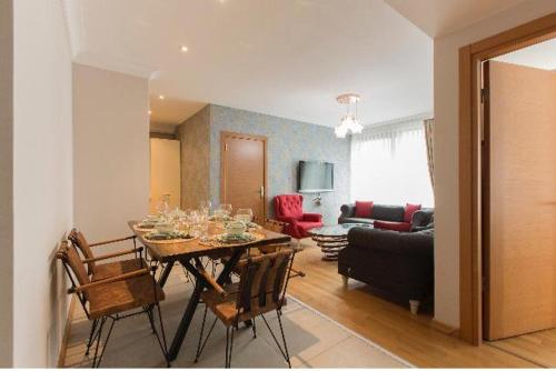 a dining room with a table and chairs and a living room at CTS Elysium Residence Taksim in Istanbul