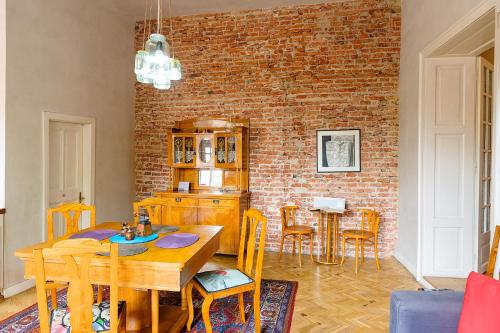 a kitchen with a wooden table and a brick wall at Cluj Apartments in Cluj-Napoca