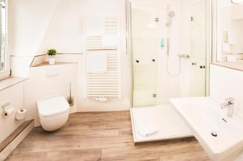 Lützow的住宿－Gasthof Scharfe Kurve，白色的浴室设有卫生间和淋浴。