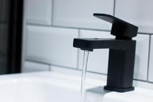 a black faucet with water coming out of it at York Street Studios in Liverpool