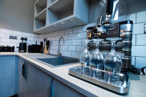 a kitchen counter with two wine glasses on a rack at York Street Studios in Liverpool