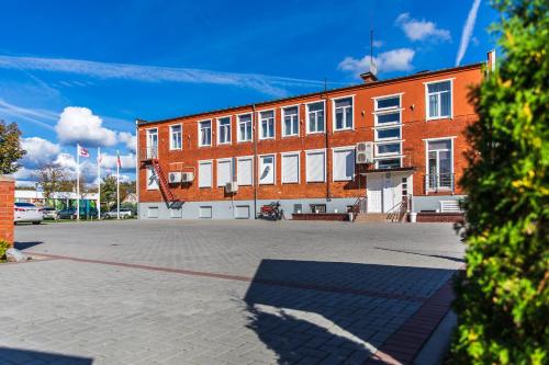 a large brick building with a large parking lot at Amber vila in Šventoji