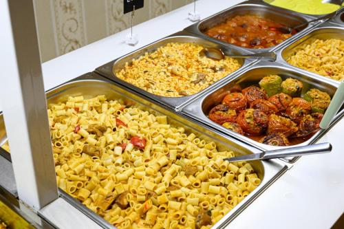 un buffet lleno de diferentes tipos de comida en bandejas en Parthenon Art Executive Wing, en Olympiakí Aktí