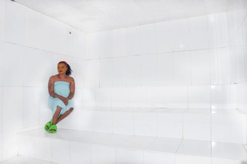 a woman sitting on a shelf in a white room at Quality Hotel Juba in Juba