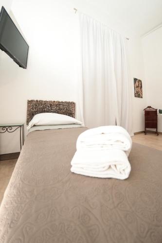 a bedroom with two beds and a flat screen tv at Casa Galione in Cava deʼ Tirreni