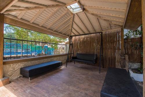 a screened in porch with a bench and a chair at StayVista's Maximus Villa - City-Center Villa with Private Pool, Gazebo, Games & Projector Room in Lonavala
