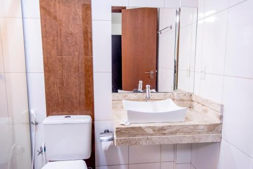 a bathroom with a sink and a toilet at Bougainville Barreiras in Barreiras