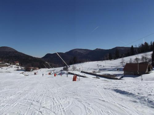 a snow covered ski slope with a ski lift at Les Sapins in Bussang