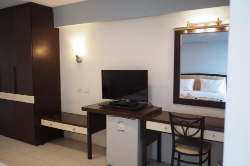 a room with a desk with a television and a bed at Phromsuk Hotel Ayutthaya in Phra Nakhon Si Ayutthaya