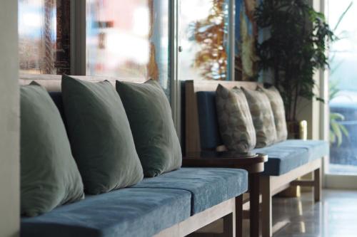a row of pillows on a bench in a room at Phromsuk Hotel Ayutthaya in Phra Nakhon Si Ayutthaya