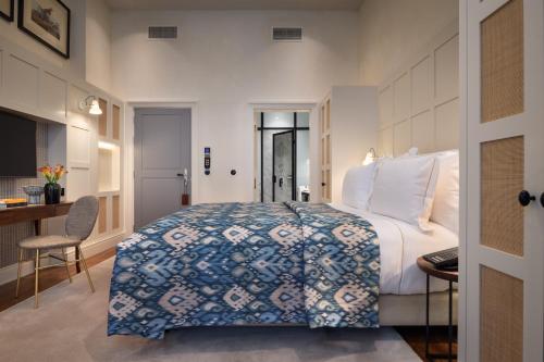 a hotel room with a large bed and a desk at Bairro Alto Hotel in Lisbon