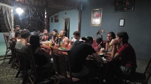 a group of people sitting around a table at Wisma Batu Mandi and offers jungle tours in Bukit Lawang