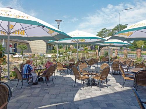 two people sitting at tables under umbrellas at a restaurant at Zur Alten Schmiede in Straelen