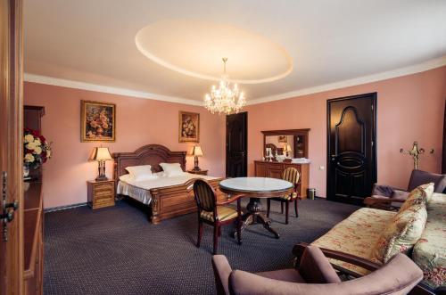 a bedroom with a bed and a table and chairs at Saban Deluxe in Lviv