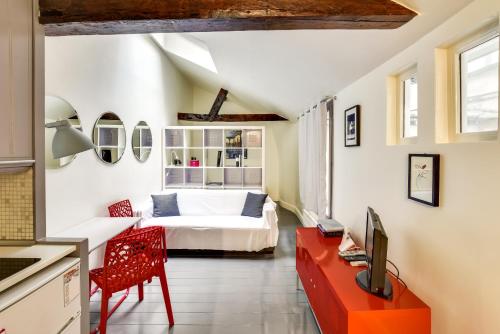 une chambre avec un lit et un bureau avec une télévision dans l'établissement Unit 011 Saint Germain des Près (Seine), à Paris