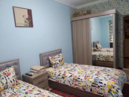 een slaapkamer met 2 bedden en een spiegel bij Samia House Twin room in Tasjkent