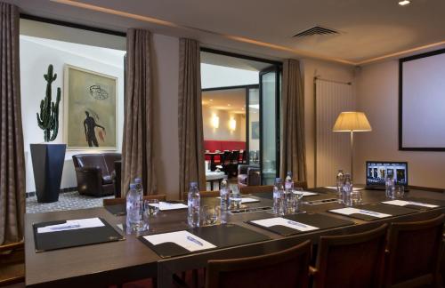 a conference room with a long table and chairs at Hôtel Le Colisée in Paris