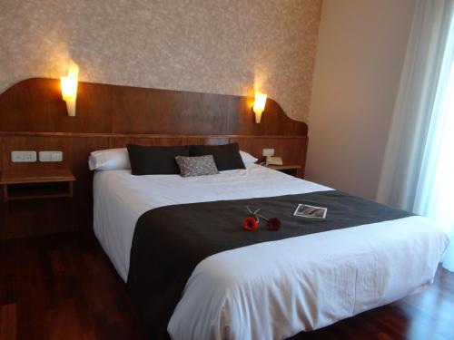 a hotel room with a bed with two apples on it at Hotel El Pescador in Perillo