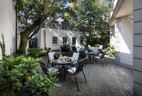 un patio con mesas y sillas frente a una casa en Willa Marea, en Sopot