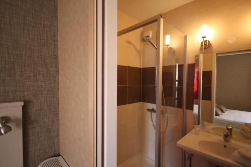 uma casa de banho com um chuveiro e um lavatório. em Hôtel d'Arcins em Latresne