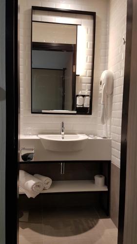 a bathroom with a sink and a mirror at Aerotel London Heathrow Airport, Terminal 2 & Terminal 3 in Hillingdon