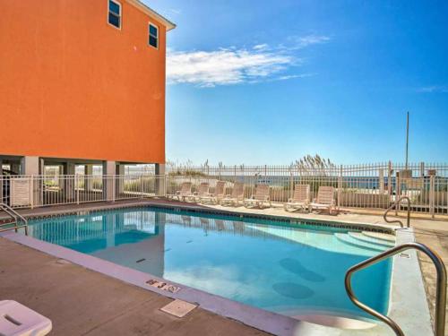a swimming pool with chairs and a building at Bill’s at Gulf Shores in Gulf Shores