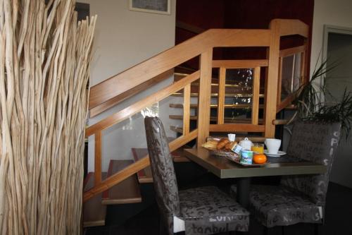 a table and chairs with food on it at Hôtel d'Arcins in Latresne