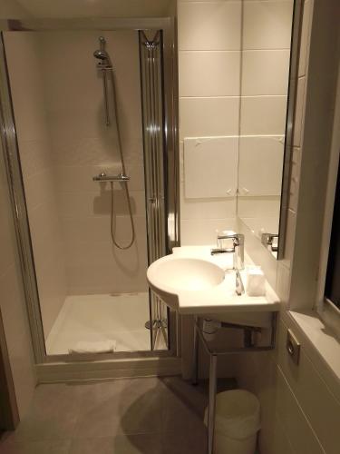 une salle de bain avec un lavabo et une douche dans l'établissement Kyriad Quimper Sud, à Quimper