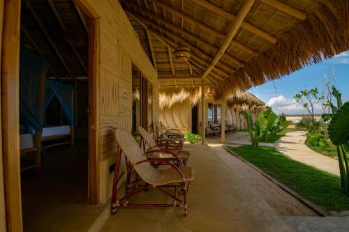 a porch of a resort with chairs on it at Blue Waters in Arugam Bay